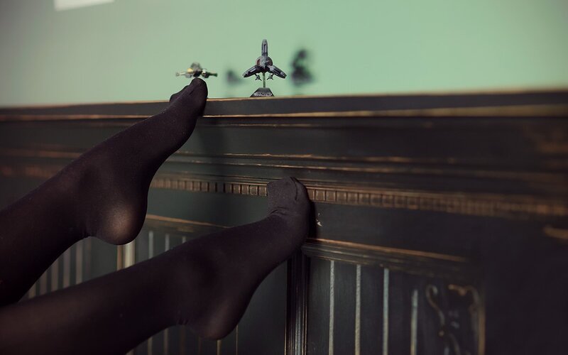 feet on a cabinet with toy ships