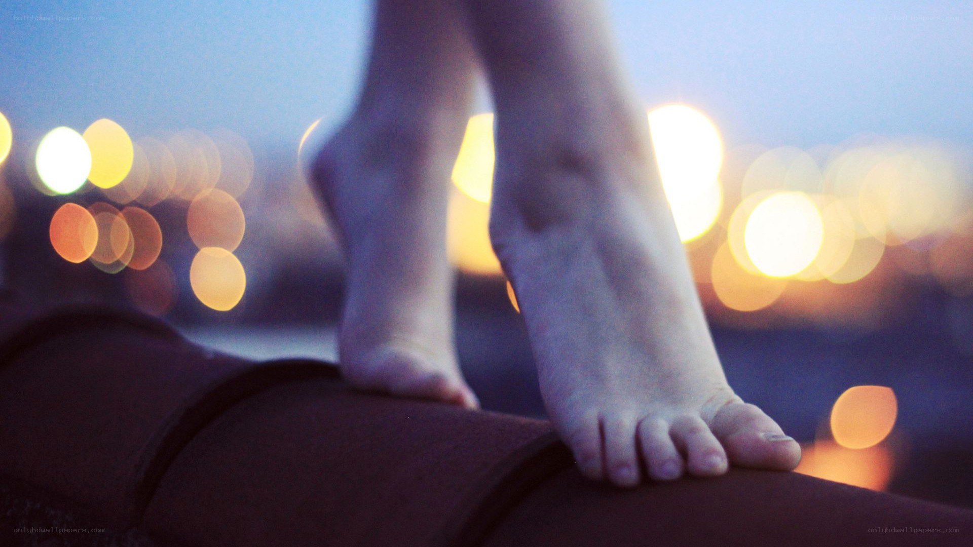 feet on a rooftop at dusk