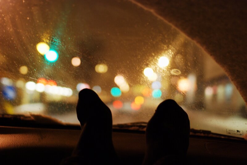 feet on car dashboard at night