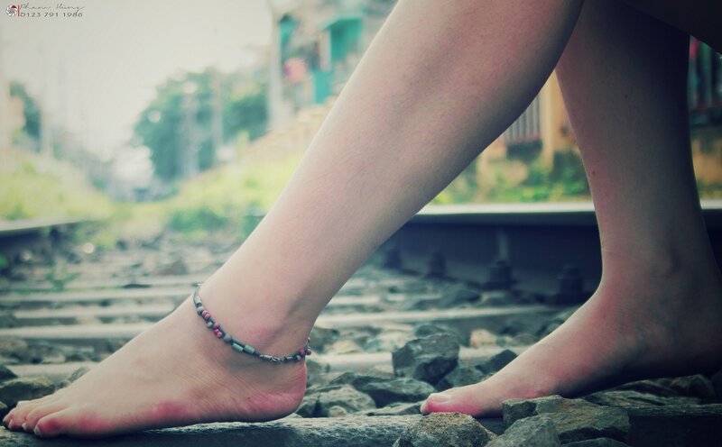 feet on train tracks