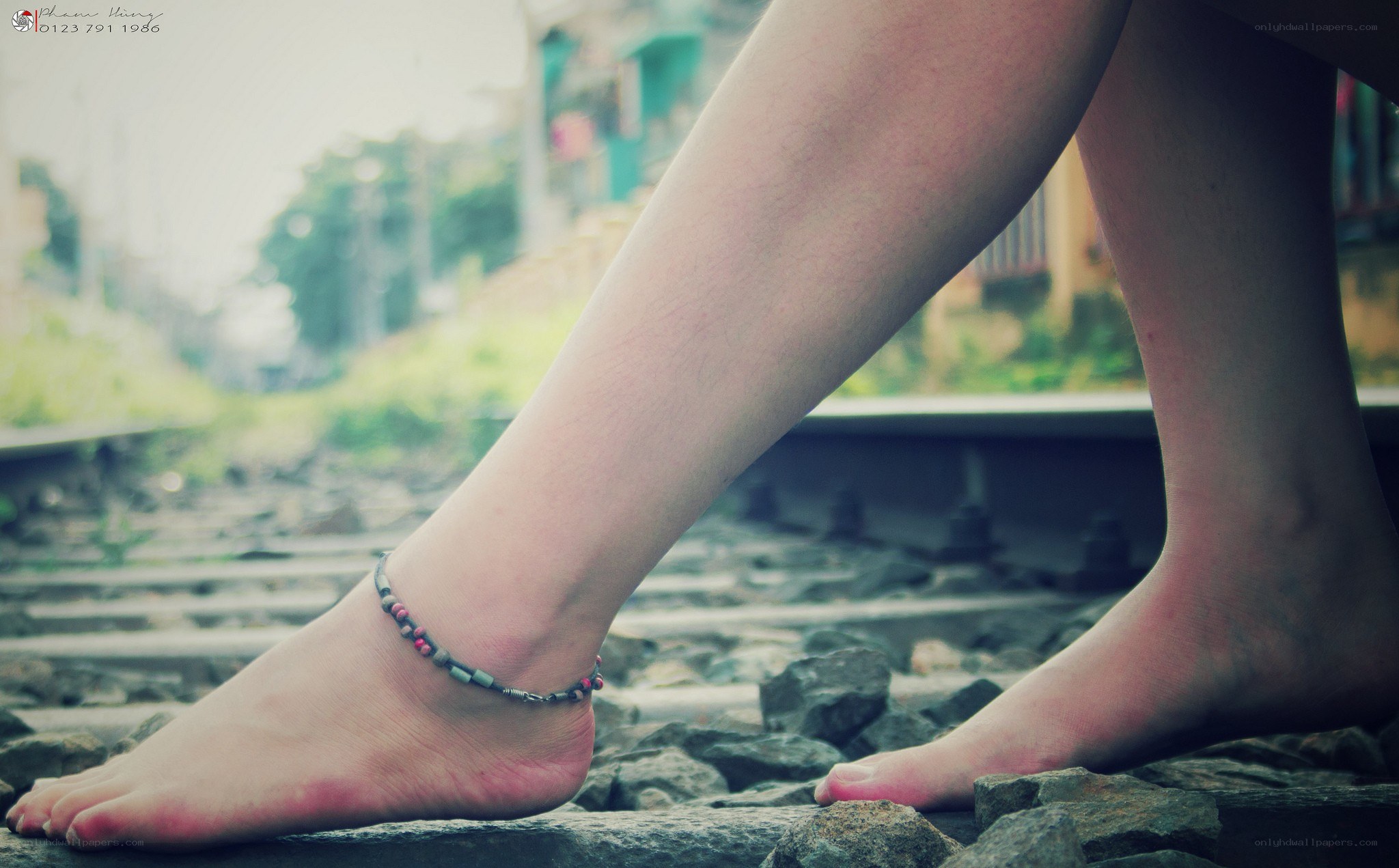feet on train tracks
