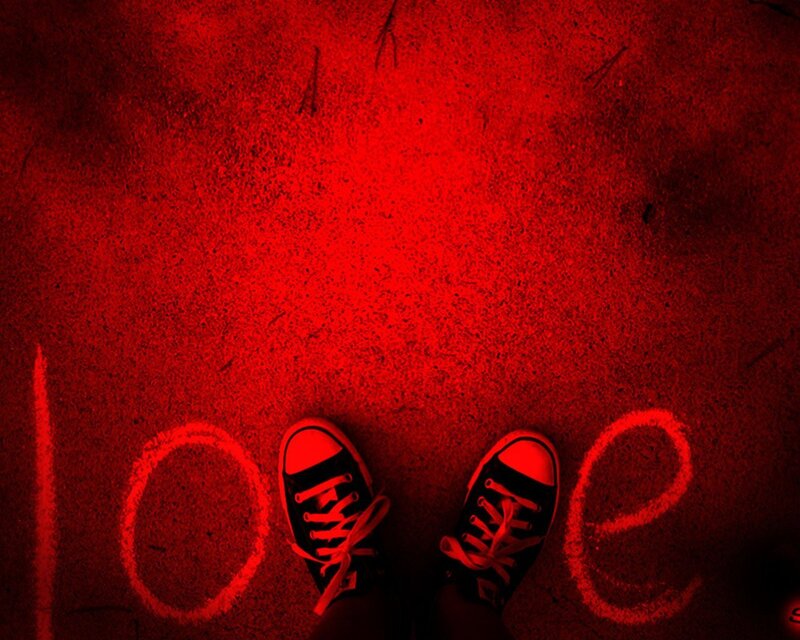 feet standing on red ground with love written