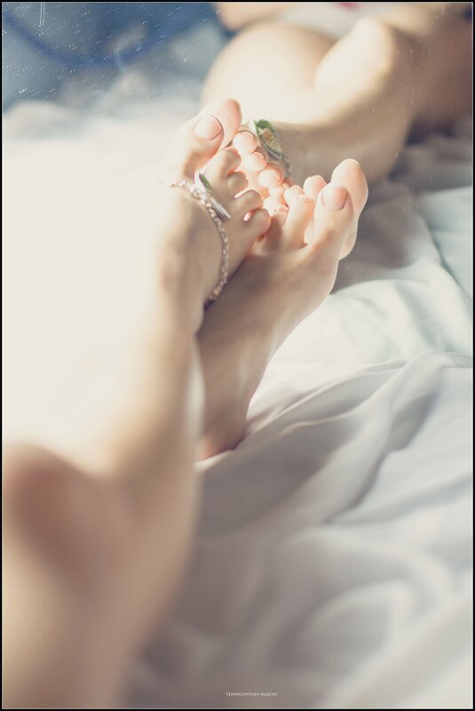 feet with anklets on bed