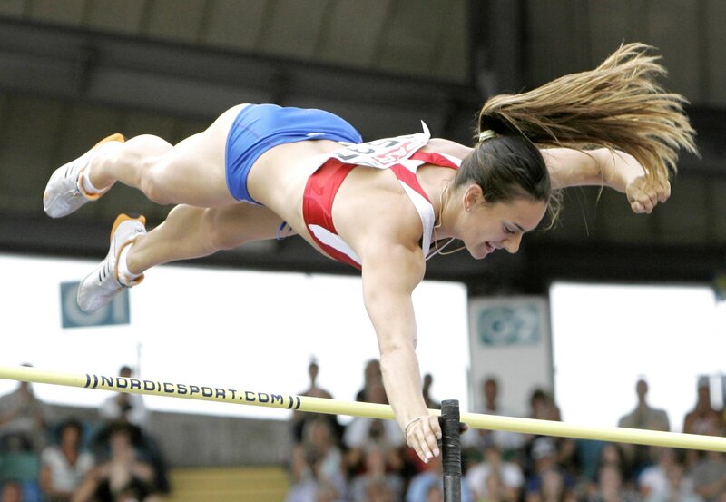 Female athlete clearing high jump bar