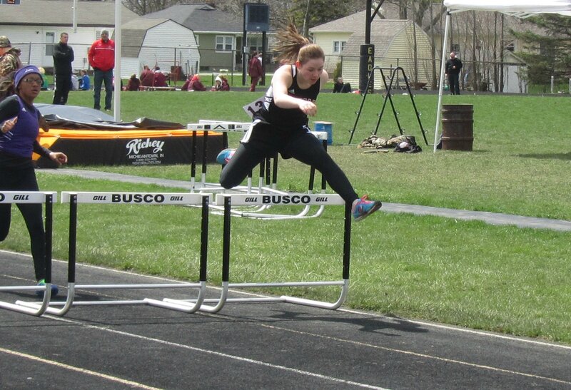 Female Athlete Jumping Hurdles