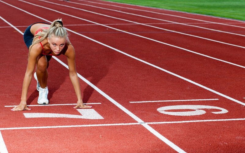 Female Runner on Track — Red