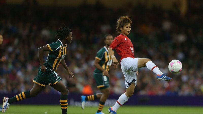 Female Soccer Player Kicking Ball — Red