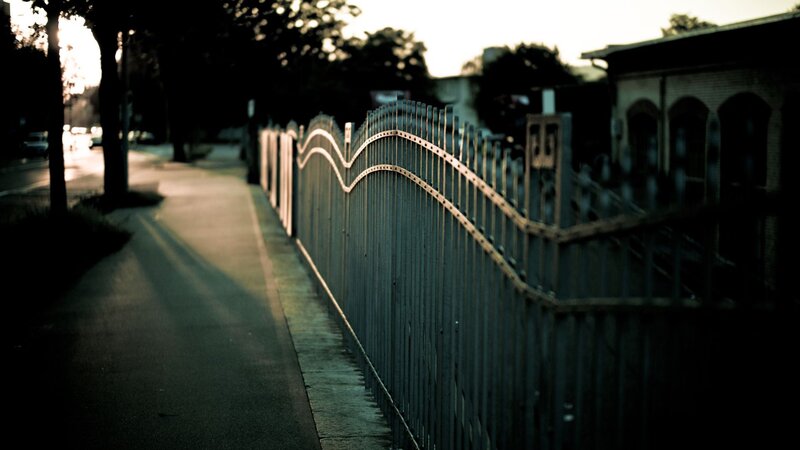 fence along a quiet sidewalk