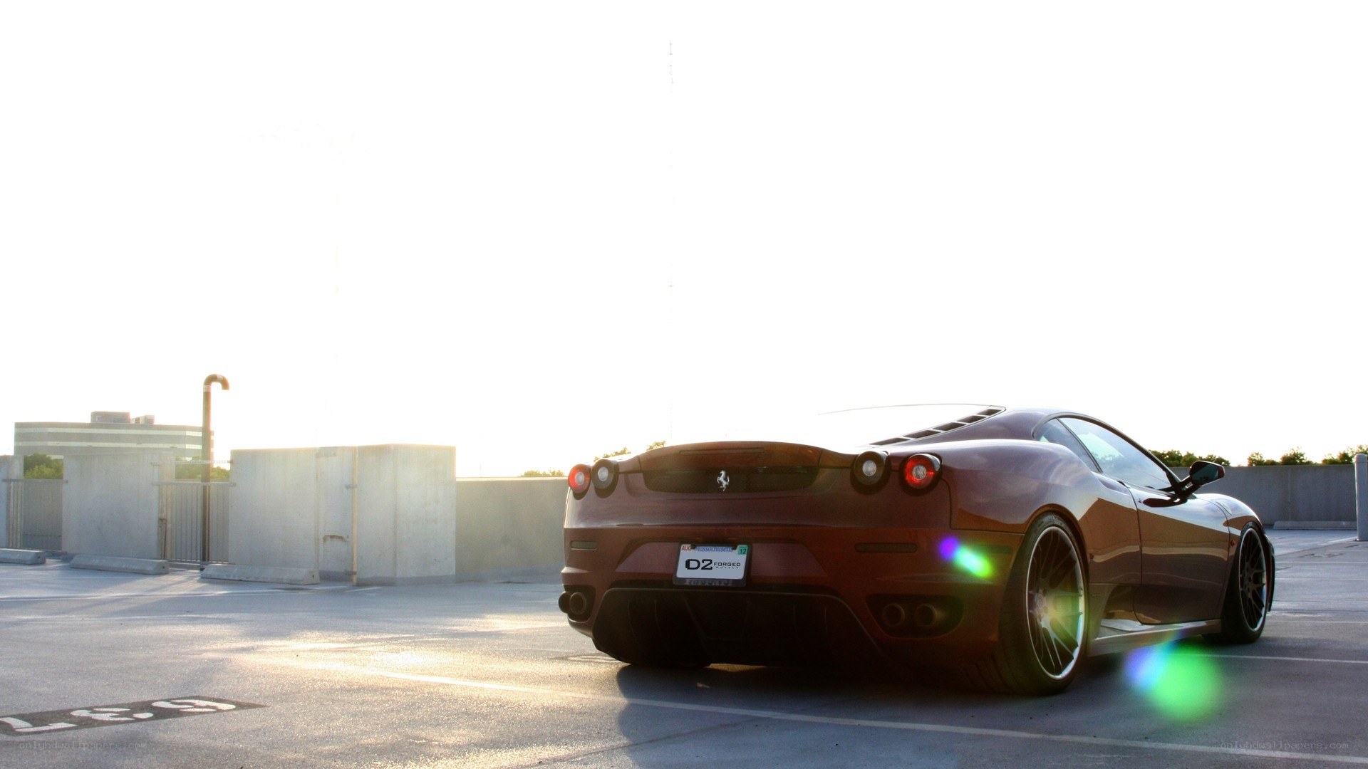Ferrari in parking lot at sunset