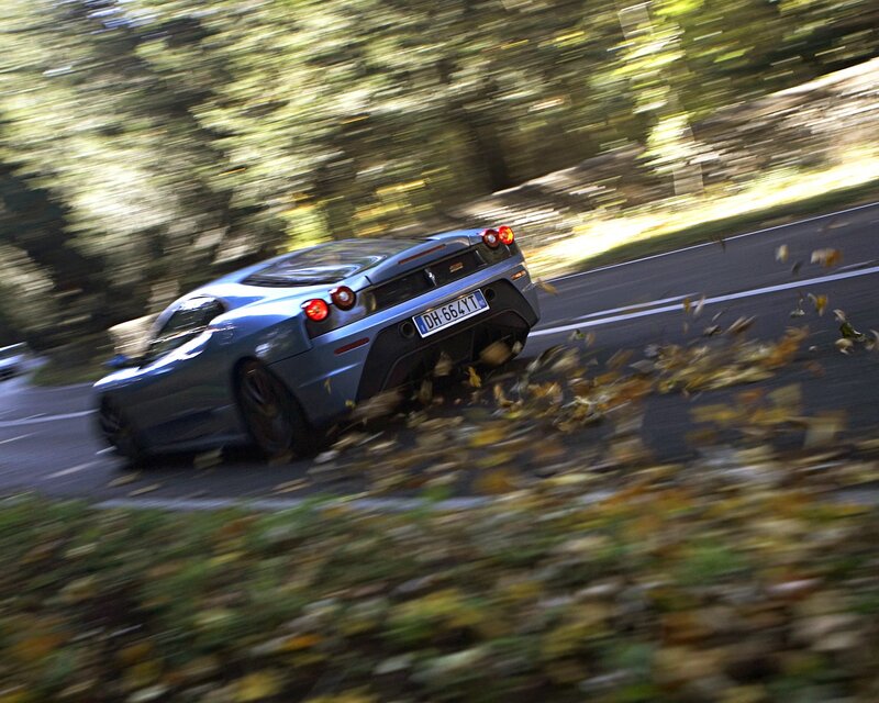 Ferrari speeding on a leafy road