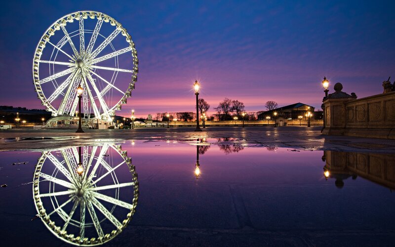 Ferris wheel at dusk with reflection