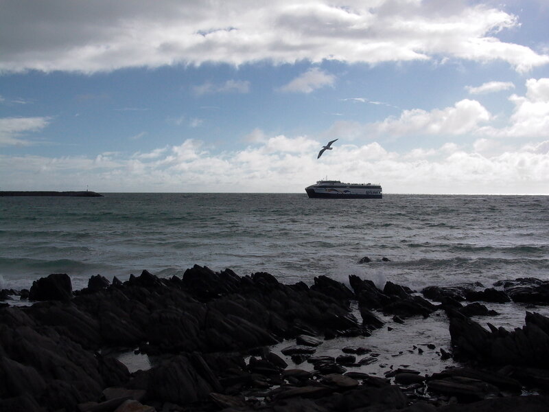Ferry at sea near rocky shore