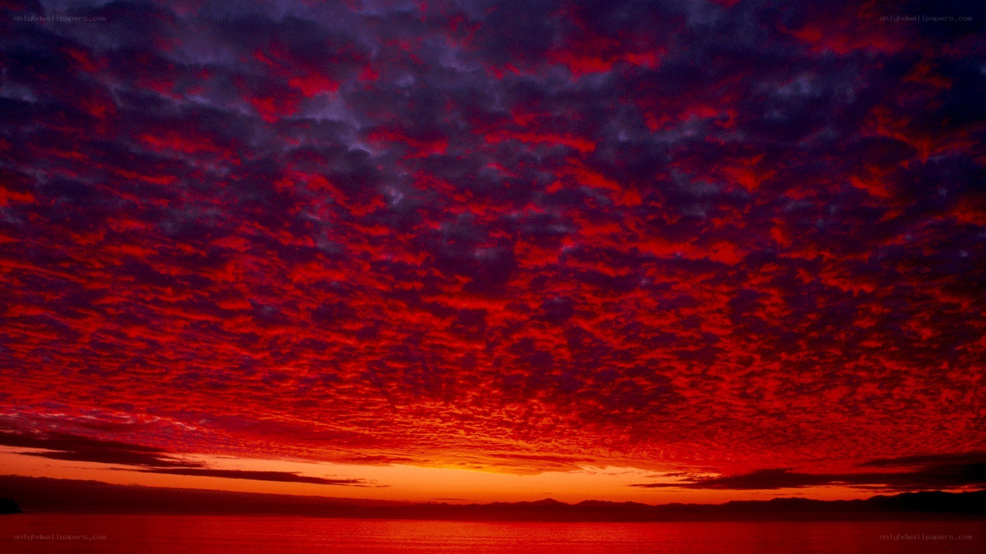 Fiery red sunset over water
