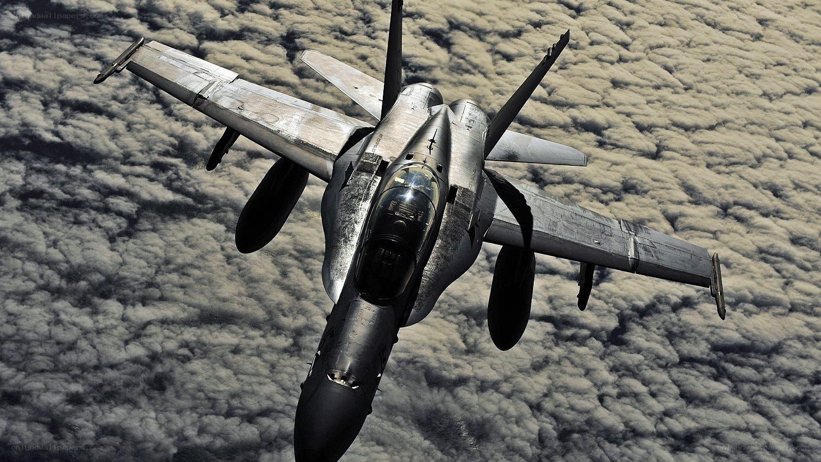 fighter jet above clouds