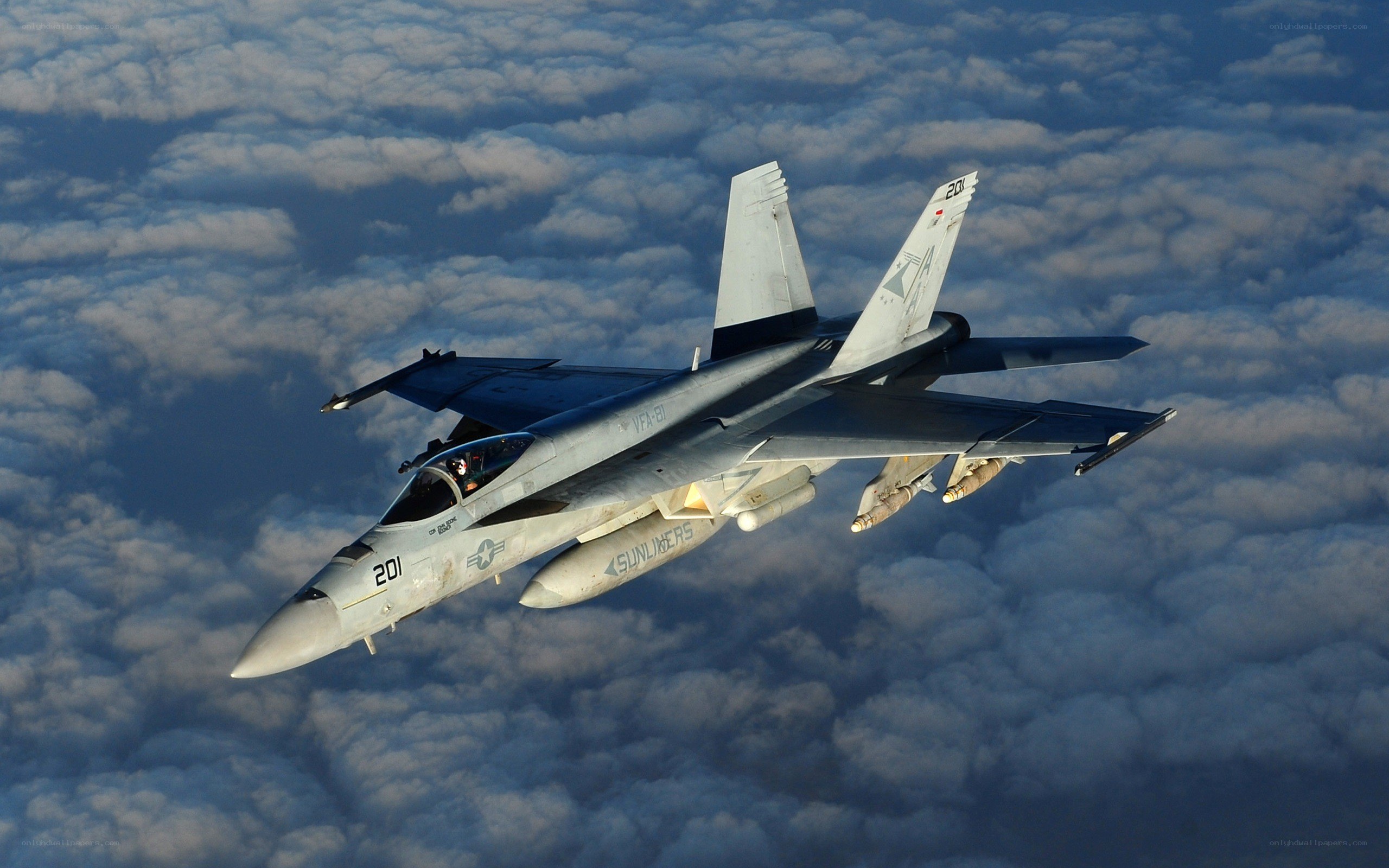 fighter jet above clouds