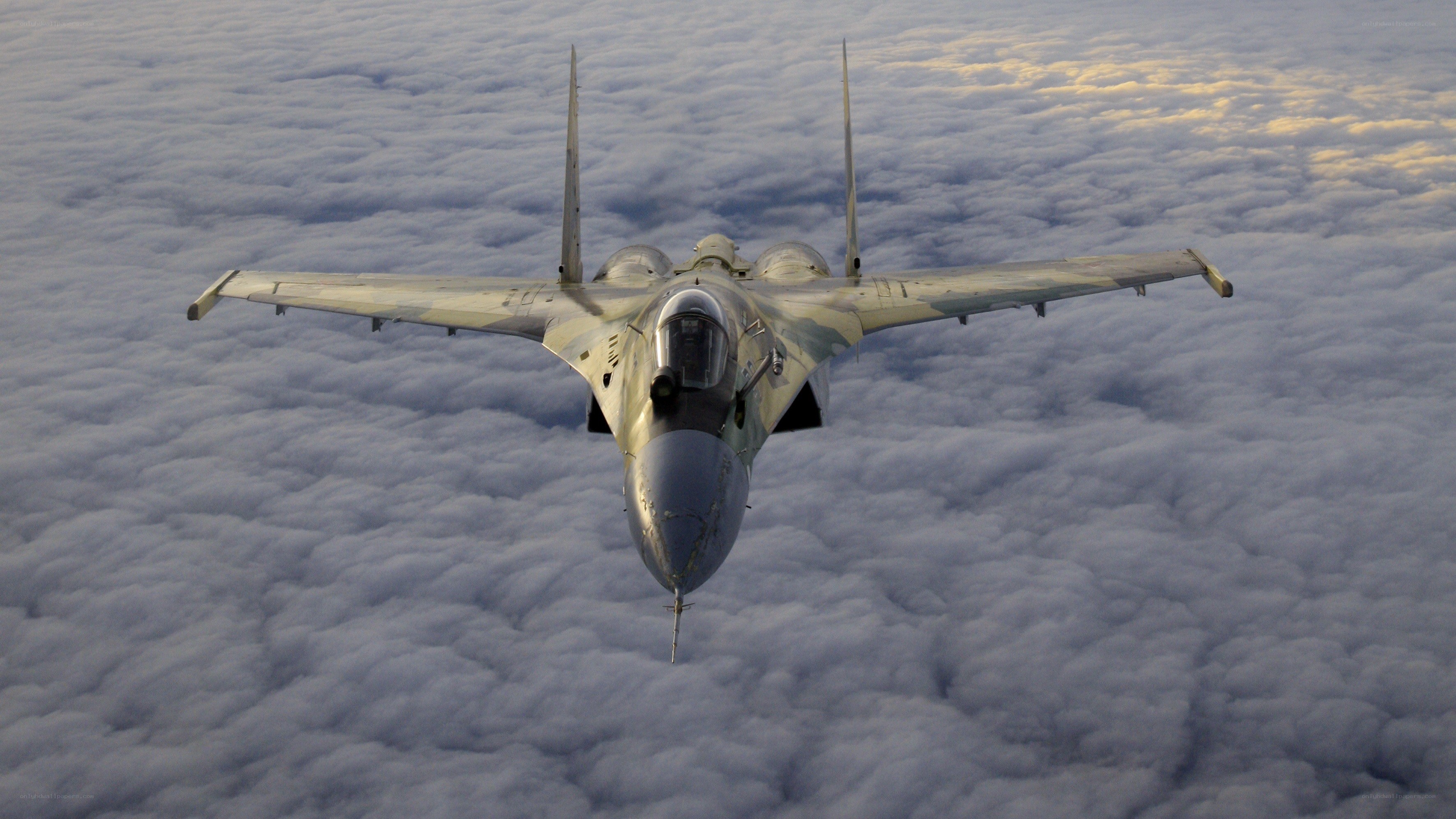 fighter jet above clouds