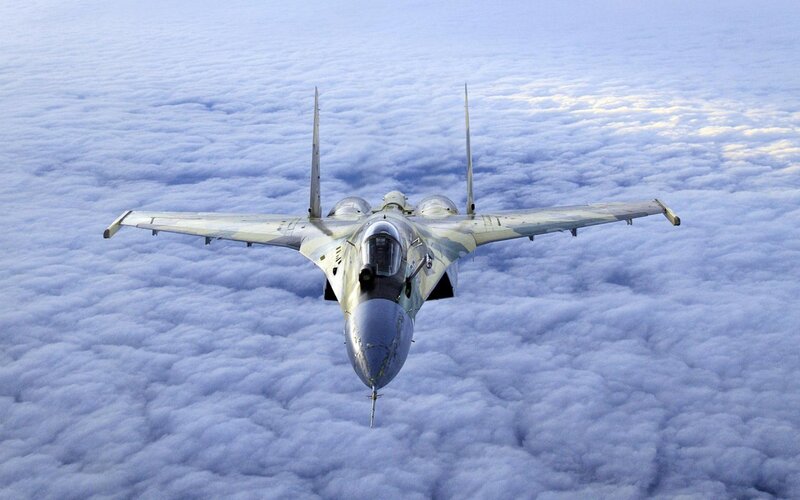 fighter jet above clouds
