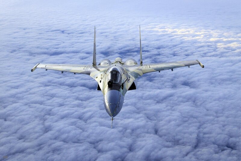 fighter jet above clouds