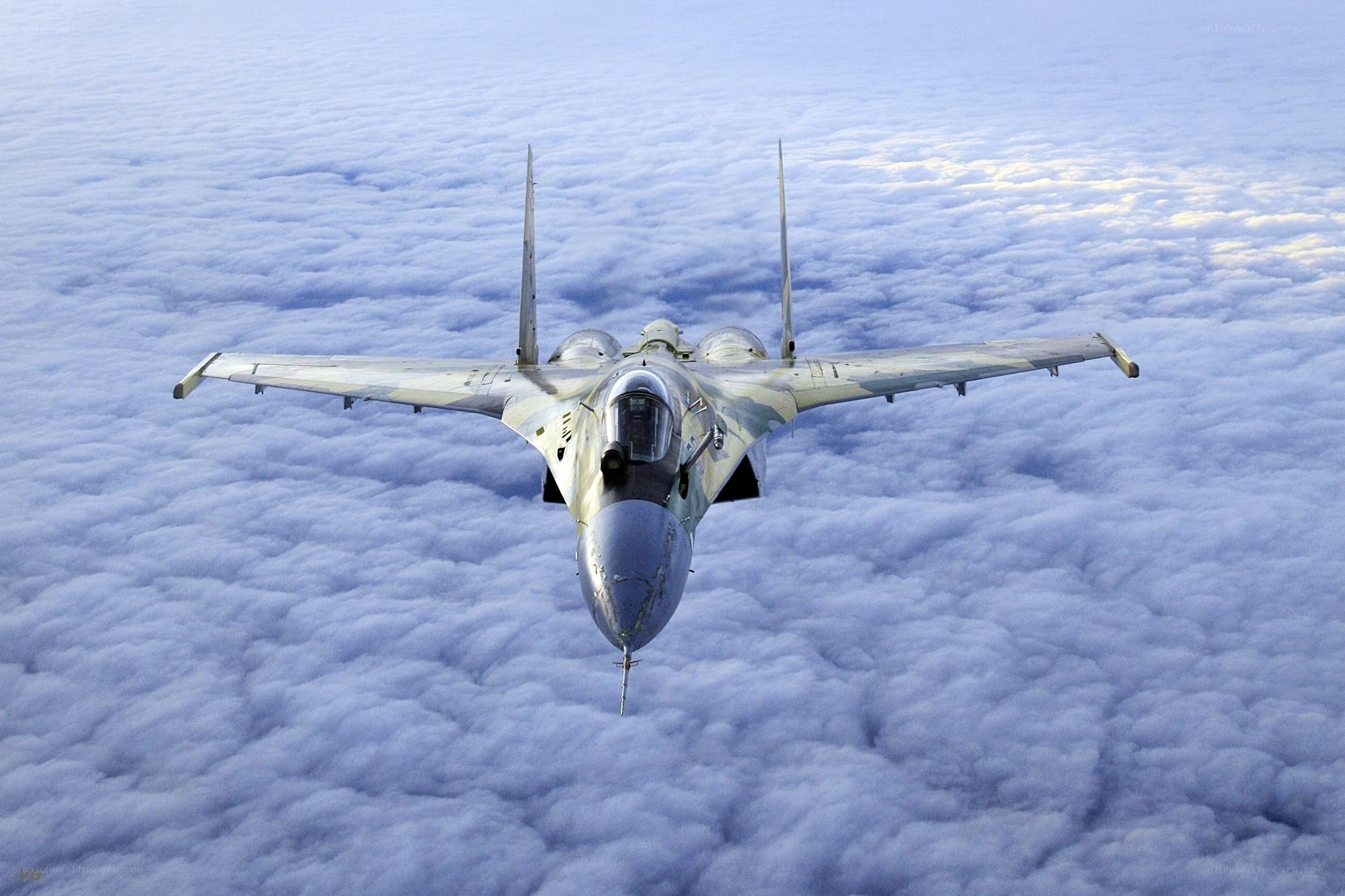 fighter jet above clouds