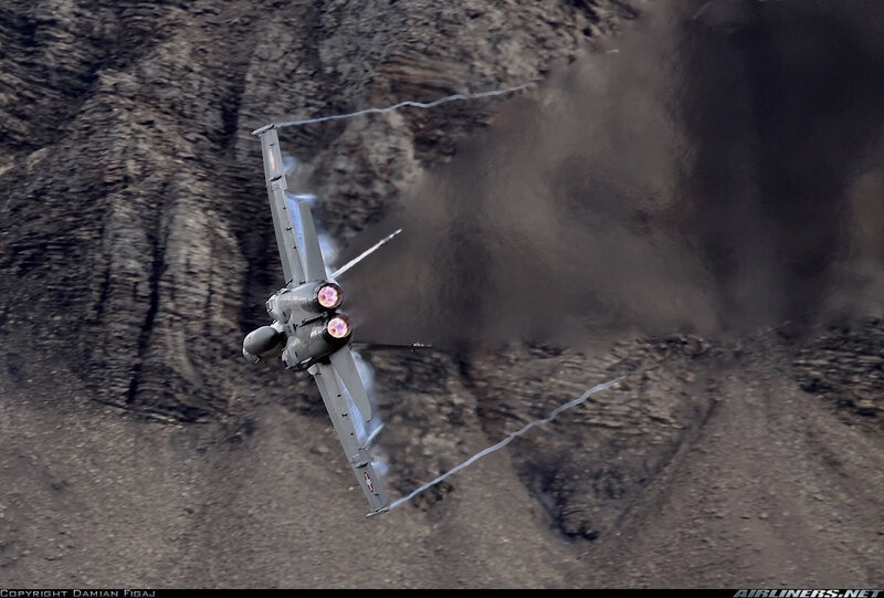 Fighter Jet in Flight — Gray, Dramatic, Photograph, Rocky Terrain