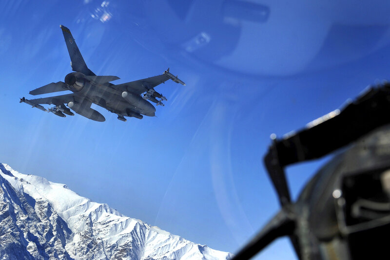 Fighter jet in flight over mountains