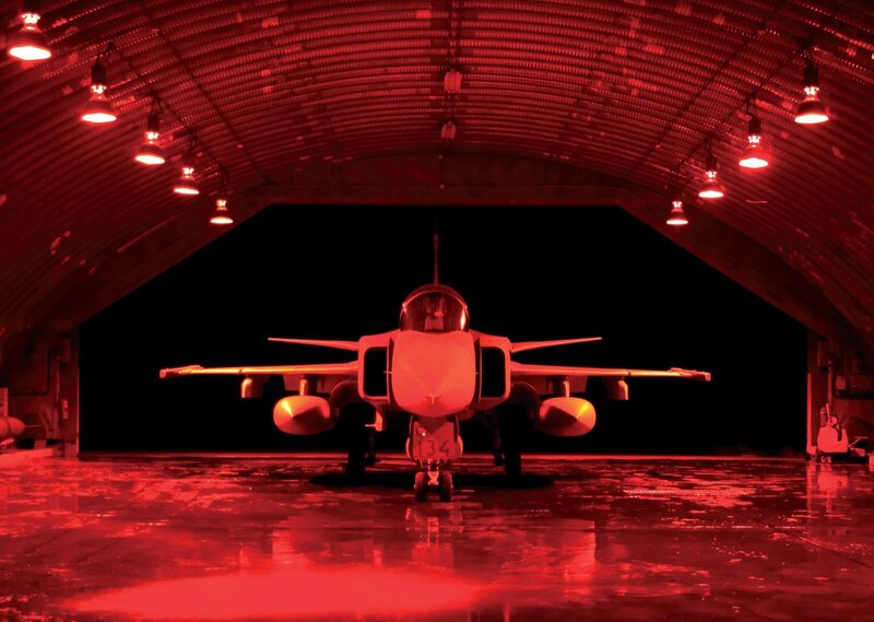 Fighter jet in red-lit hangar