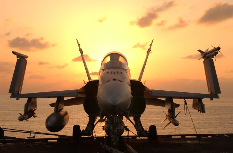 Fighter jet on aircraft carrier at sunset