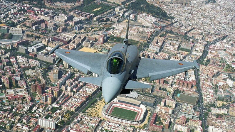 Fighter Jet over City — Gray, Dramatic, Afternoon, Photograph, Stadium, Buildings