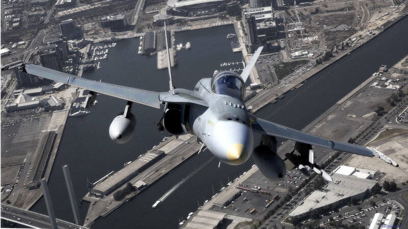 fighter jet over city harbor