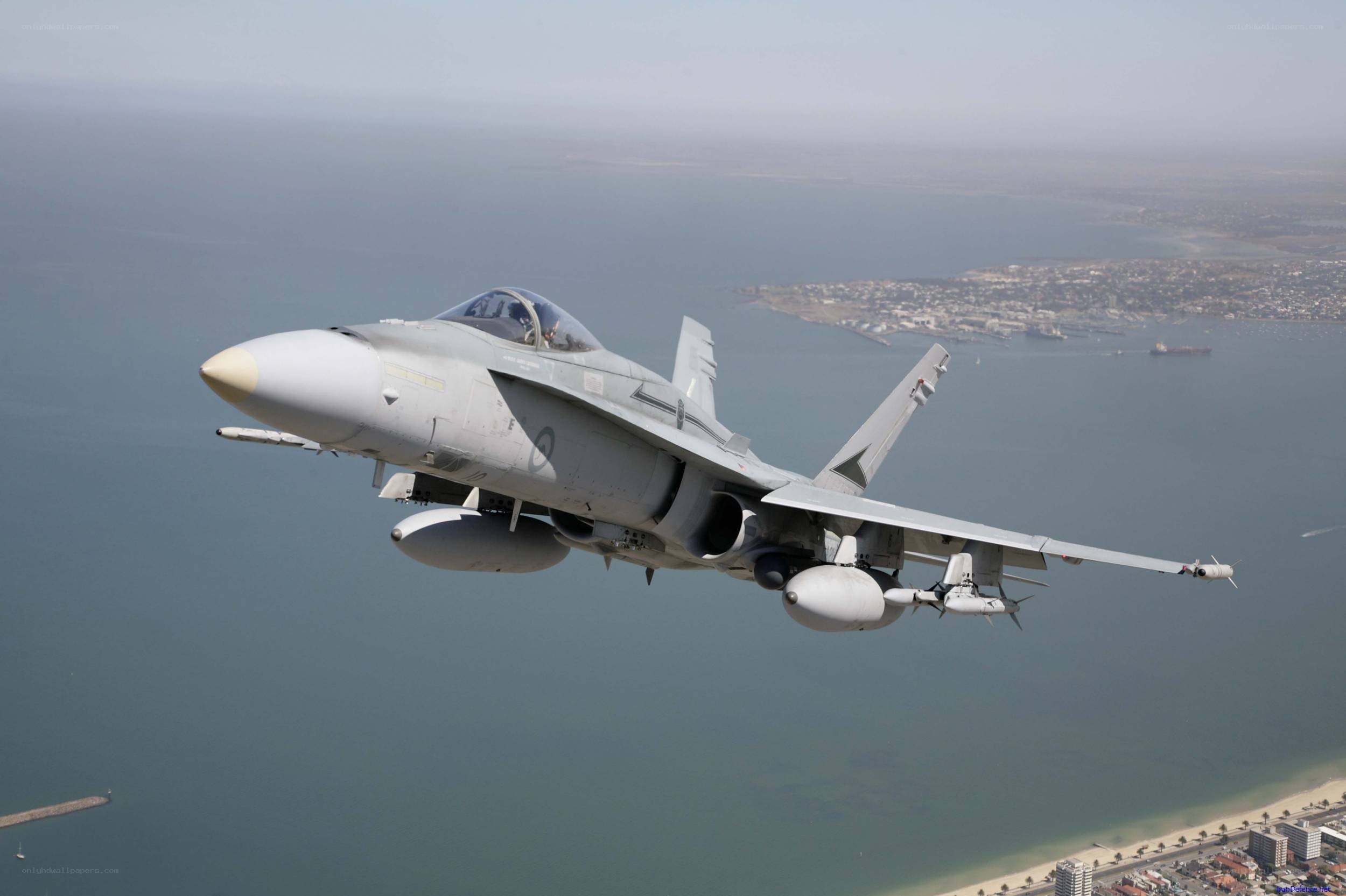 fighter jet over coastal city