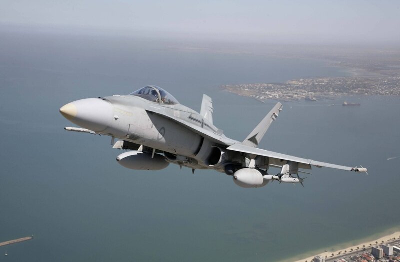 fighter jet over coastal city