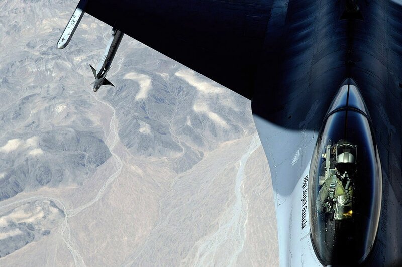 Fighter jet over desert terrain