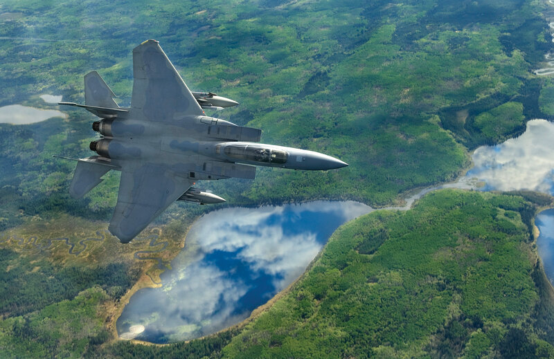 fighter jet over forest landscape