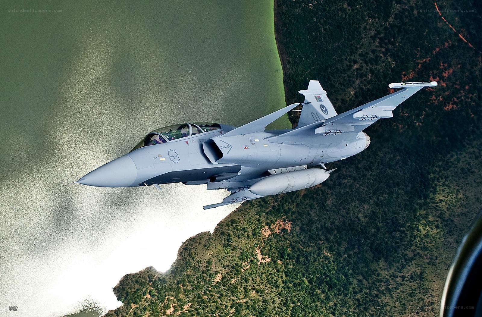 fighter jet over lake and forest