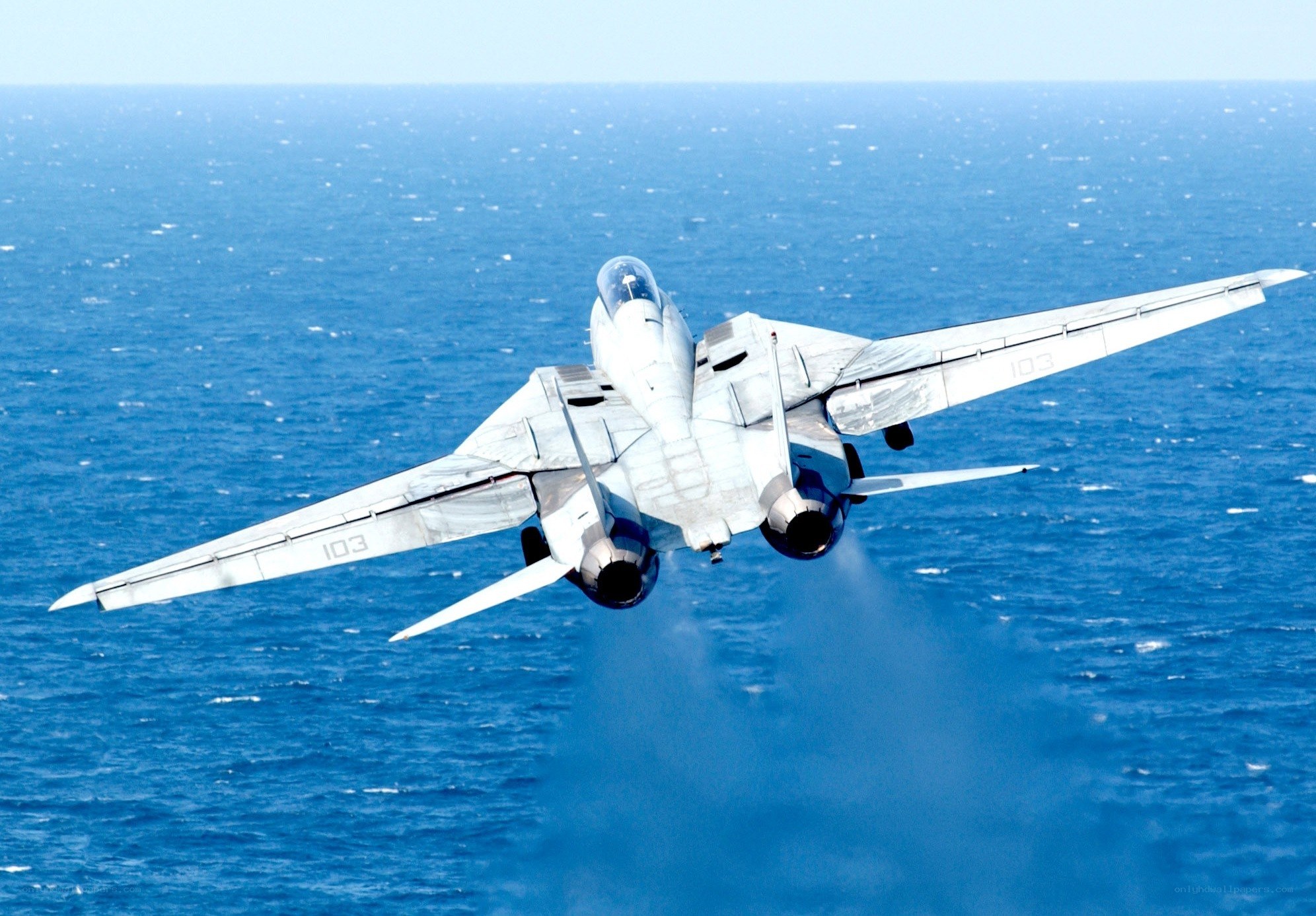 fighter jet over ocean