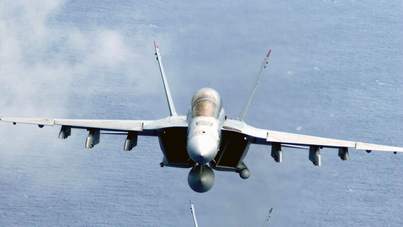 fighter jet over ocean