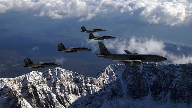 Fighter jets escorting a military aircraft