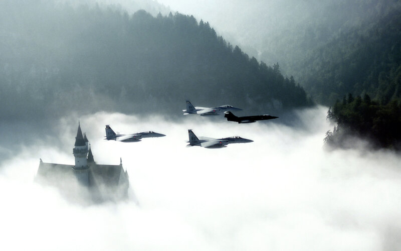 Fighter jets fly over castle in clouds
