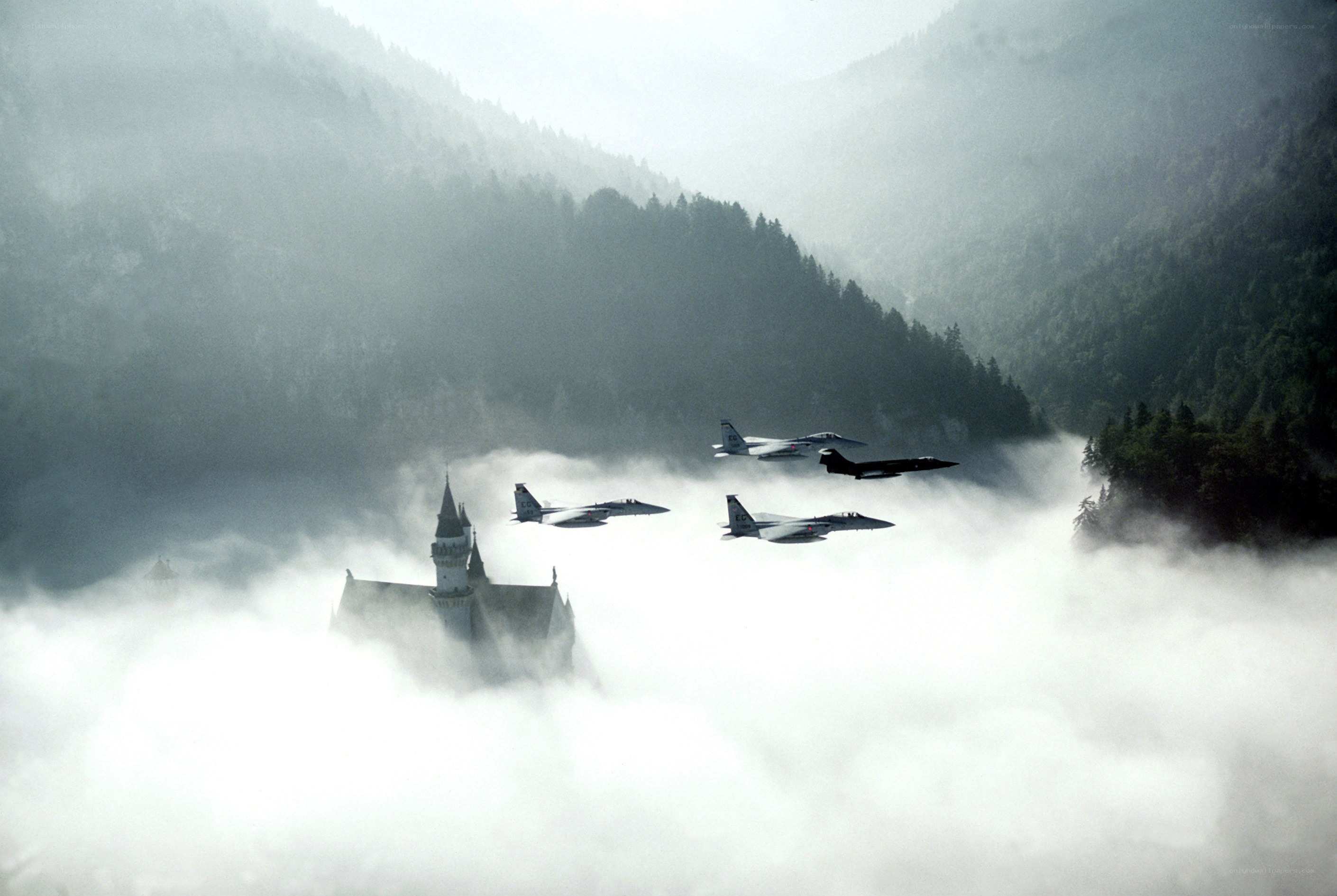 Fighter jets fly over castle in clouds