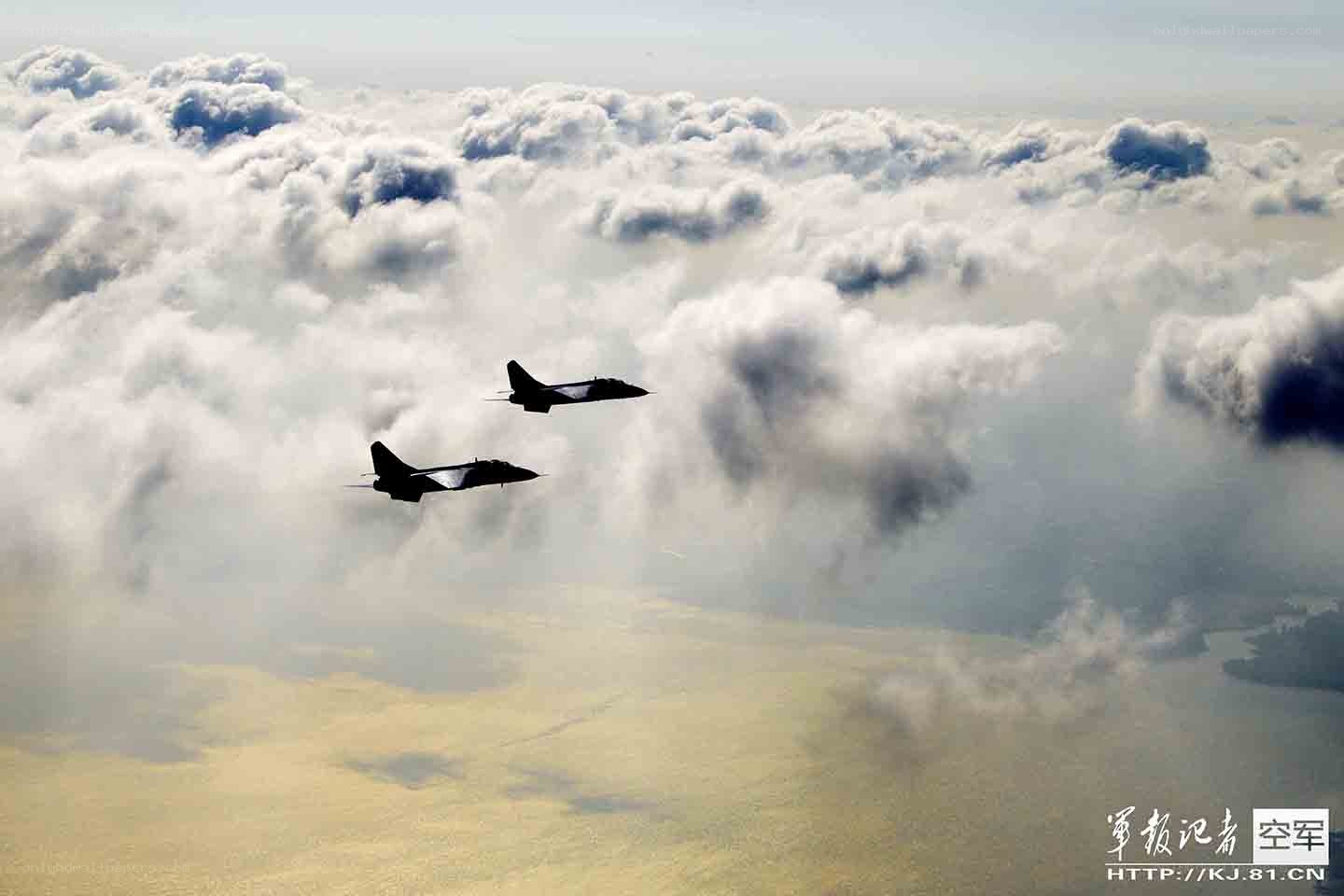 Fighter jets flying above clouds