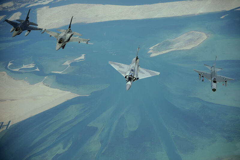 Fighter jets in formation over coastline