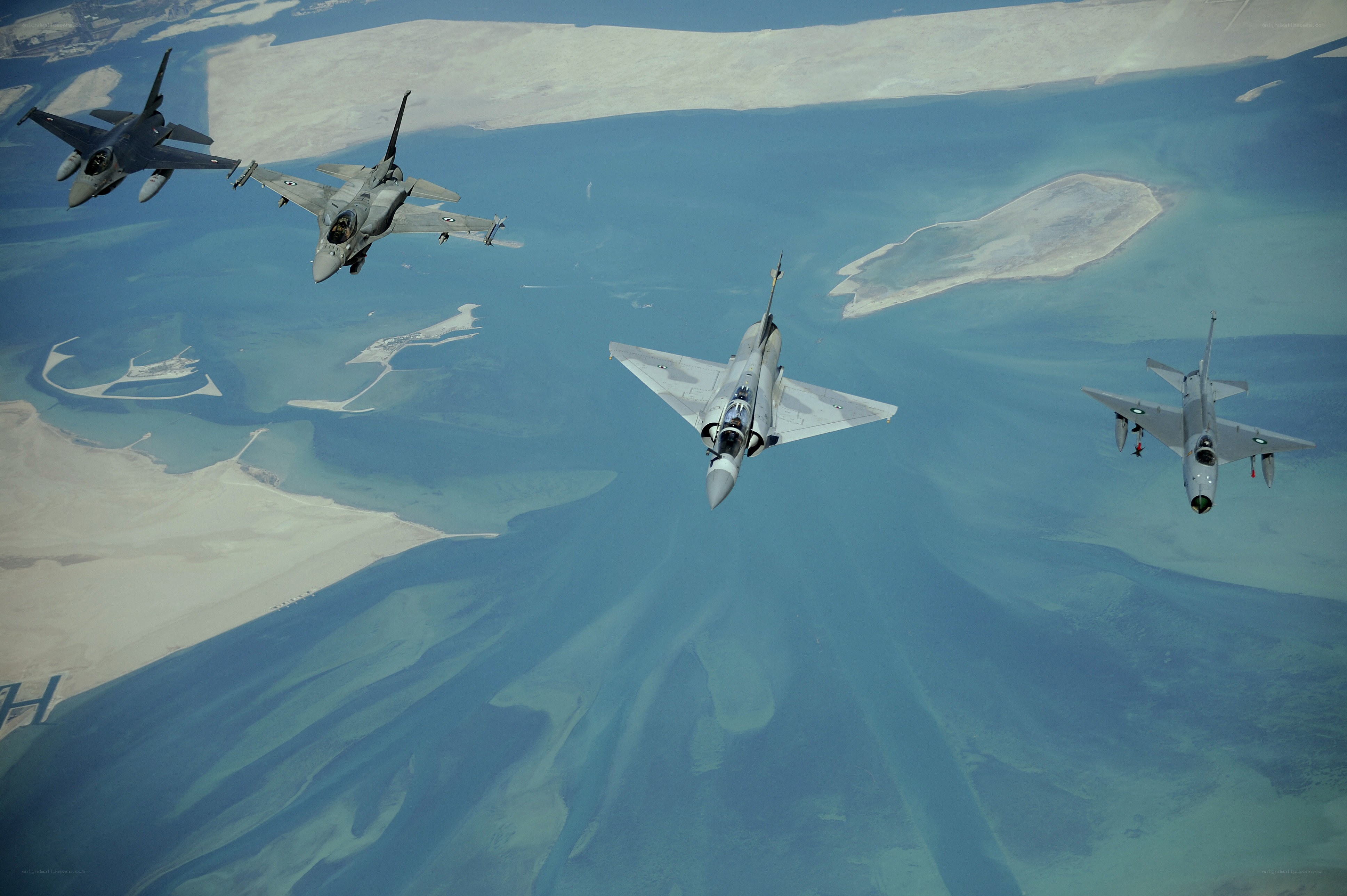Fighter jets in formation over coastline
