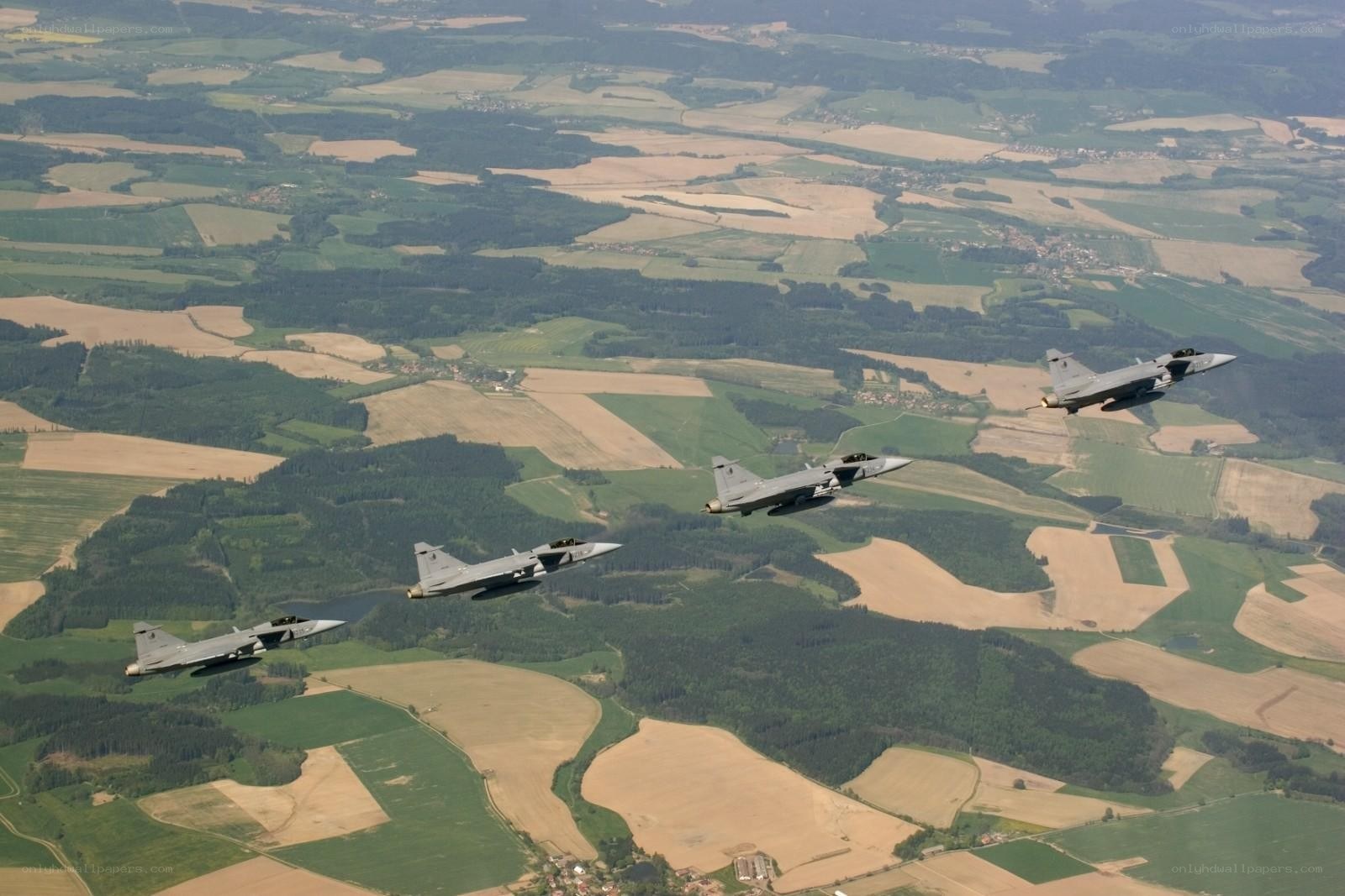 Fighter jets in formation over farmland