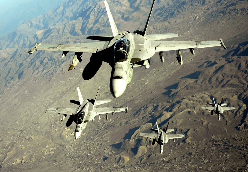 Fighter jets in formation over mountains