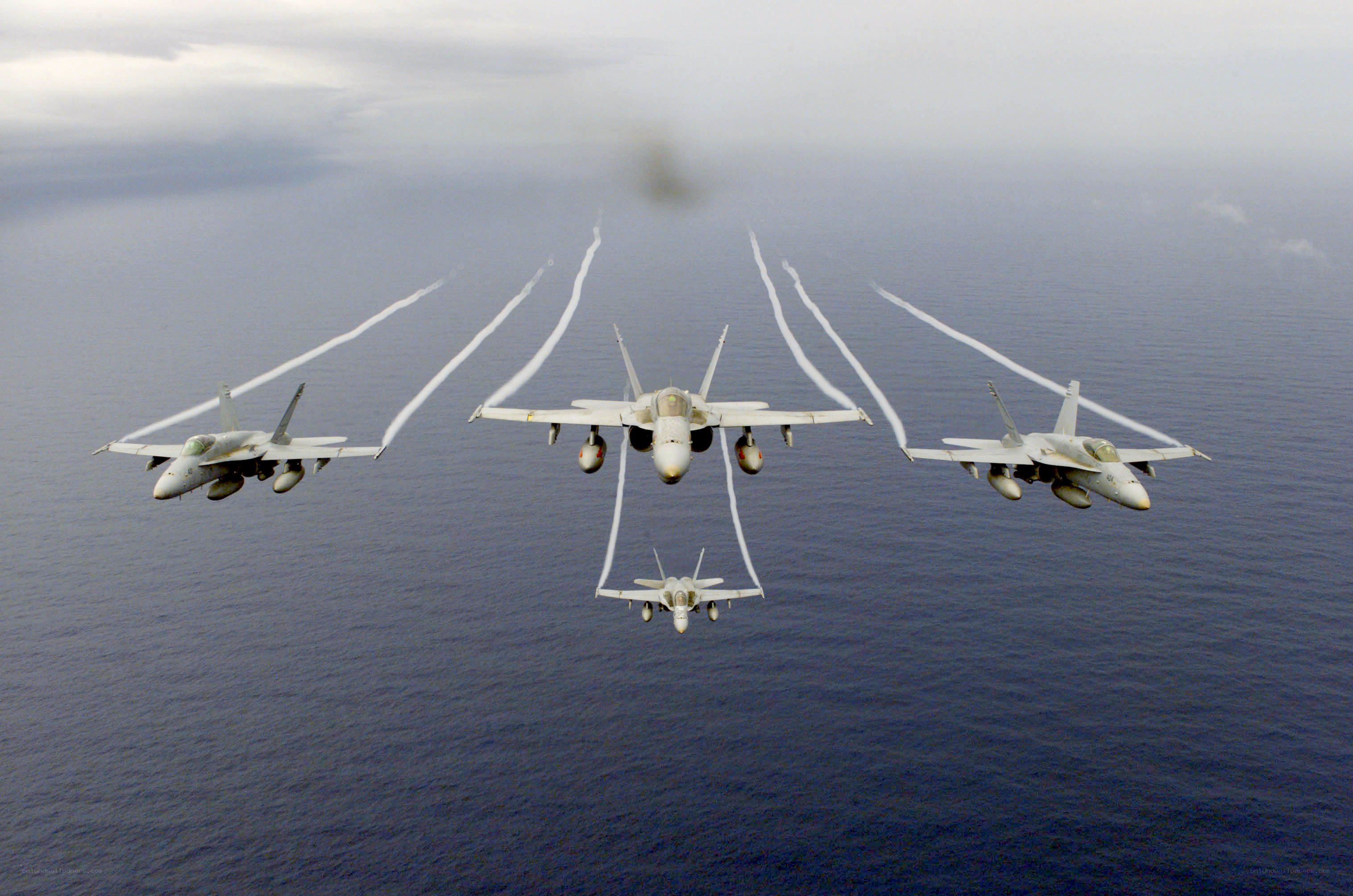 Fighter jets in formation over ocean