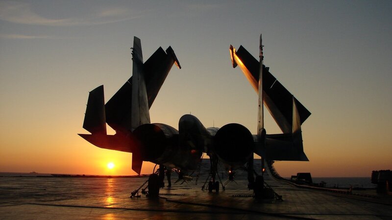 Fighter jets on aircraft carrier at sunset
