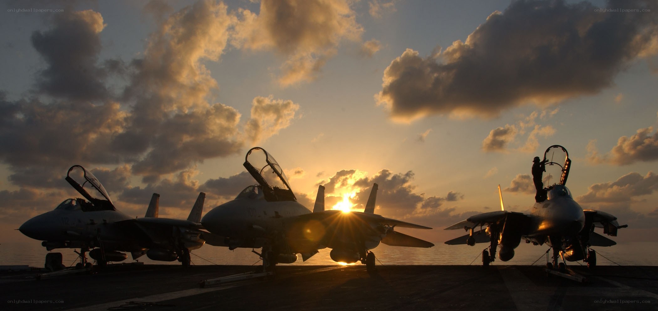 Fighter jets on aircraft carrier at sunset