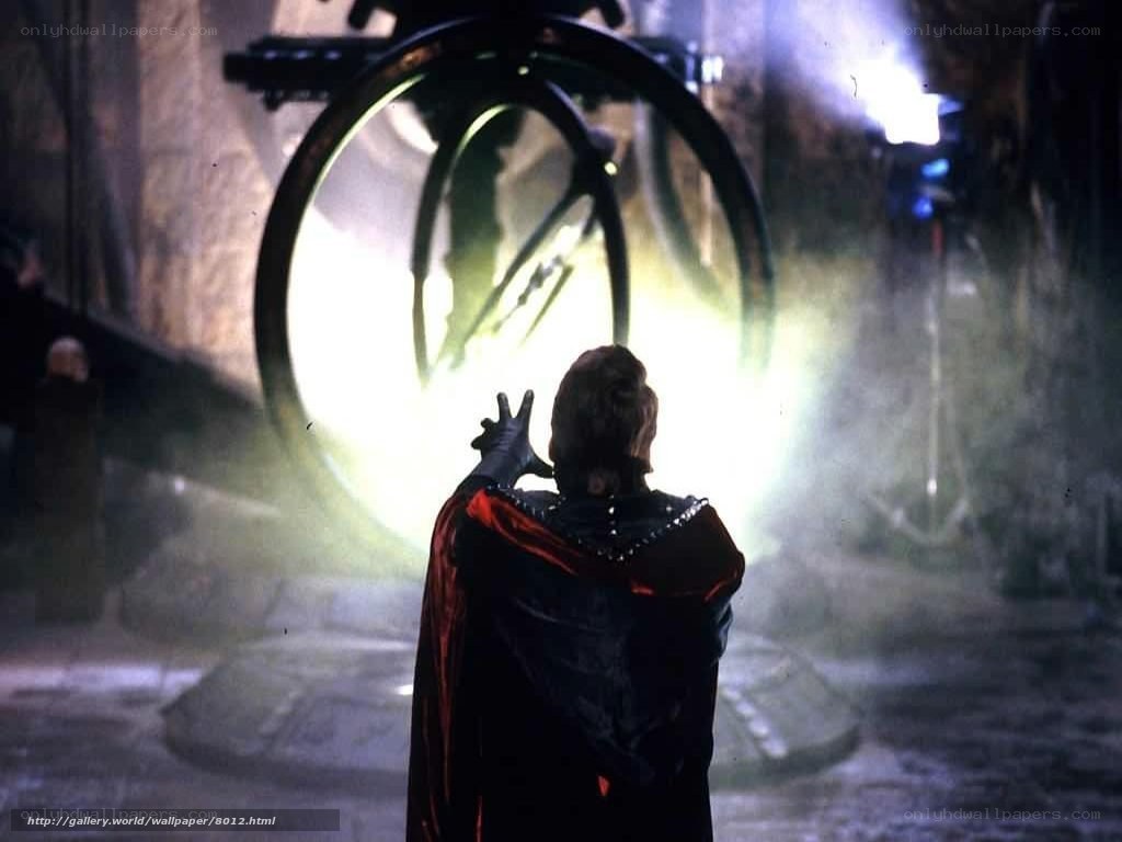 figure in cloak before glowing portal