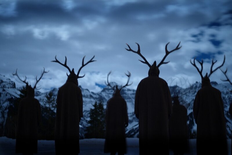 figures with antlers in snowy landscape