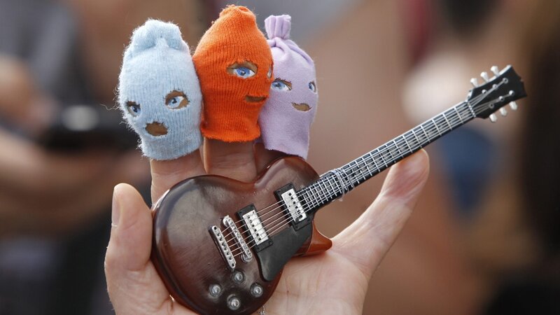 Fingers with Balaclavas Holding Guitar
